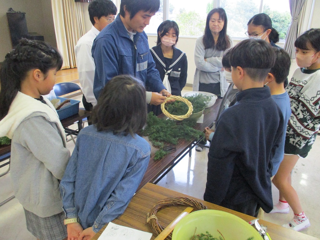 さつまスギ等を8cmに切り、土台のリースに針金で巻いてリース本体作り。の画像