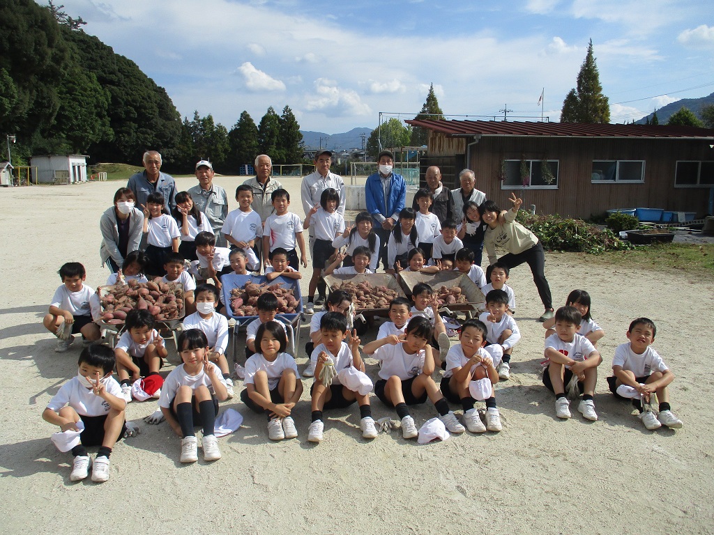 東小2年生　さつまいもと一緒にパチリの画像